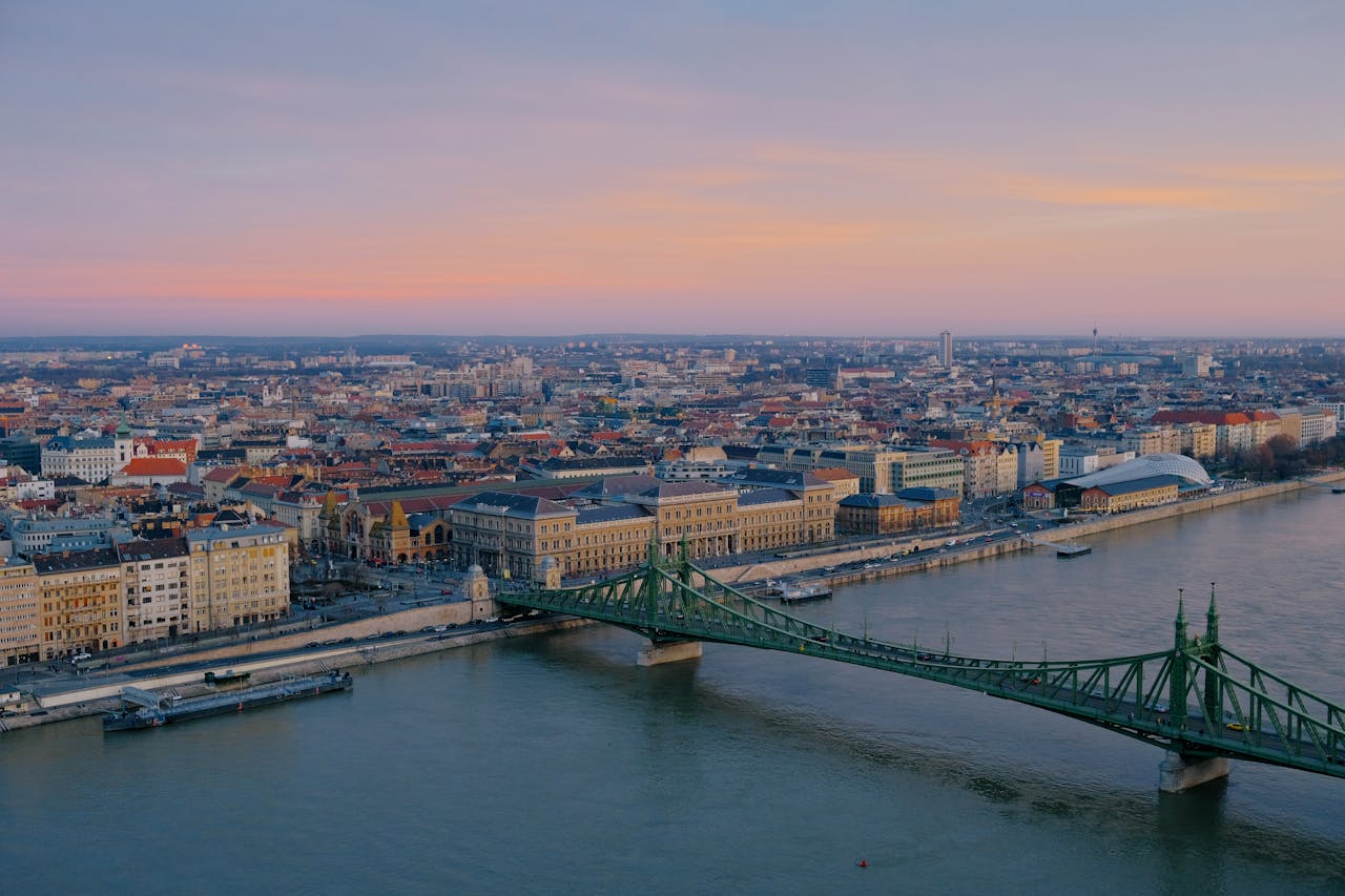 services-02 Aerial view of Liberty Bridge and Budapest skyline over the Danube River during sunset.